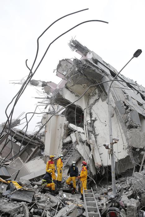 Rescue workers search a collapsed building from an early morning earthquake in Tainan, Taiwan, Saturday, Feb. 6, 2016. A powerful, shallow earthquake struck southern Taiwan before dawn Saturday. (ANSA/AP Photo/Wally Santana)