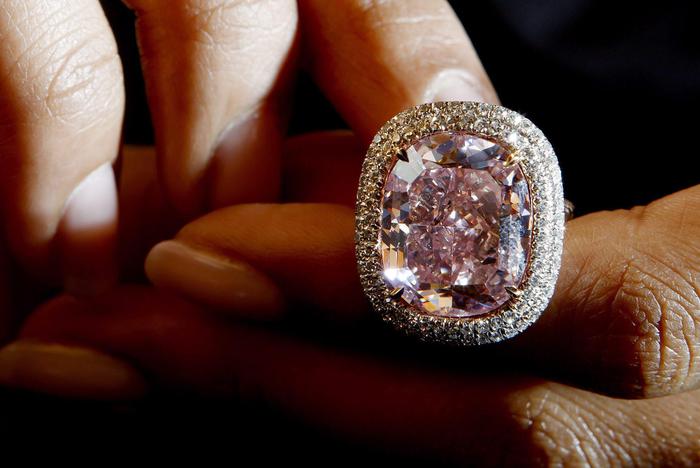 epa05003276 A Christie's employee displays a cushion-shaped fancy Vivid Pink diamond of 16.08 carats during a preview at the auction house in Geneva, Switzerland, 30 October 2015. The diamond is estimated to sell between 22,737,915 - 27,680,940 Swiss Francs (23 million - 28 million US Dollars) during Christie's Magnificent Jewels auction in Geneva on 10 November.  EPA/SALVATORE DI NOLFI